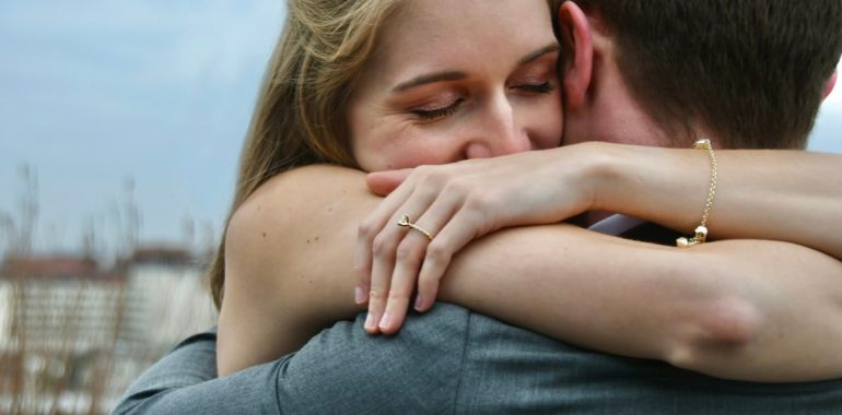 man in blue denim jeans kissing woman in white shirt